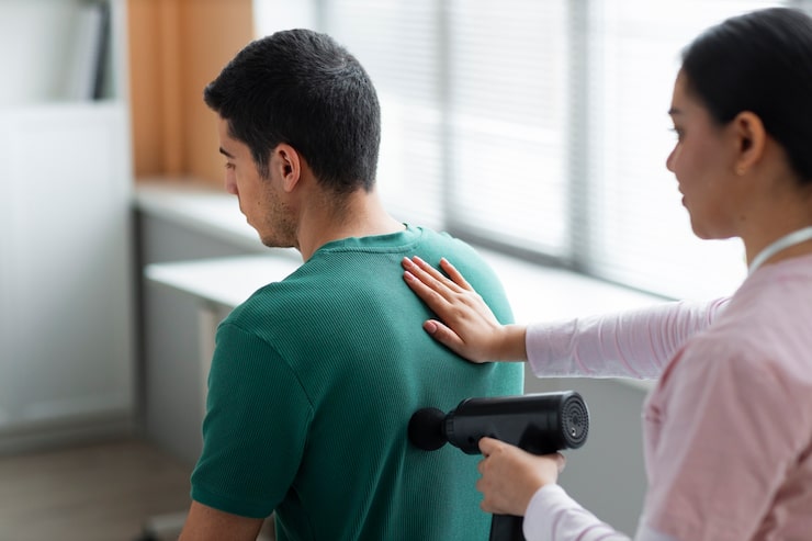 Médico ayudando a un paciente con ejercicios durante su rehabilitación en la Unidad de Cadera de Novotrauma
