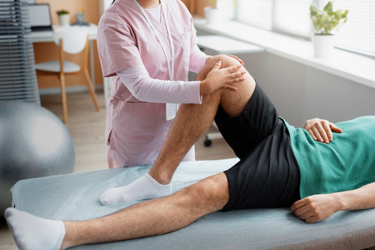 Médico evaluando y ayudando a un paciente durante su rehabilitación en Novotrauma