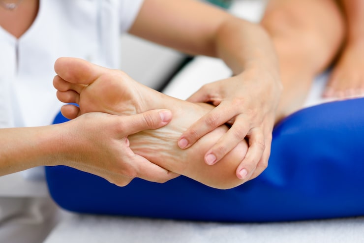 Terapeuta realizando un masaje en el pie de un paciente en un centro de fisioterapia