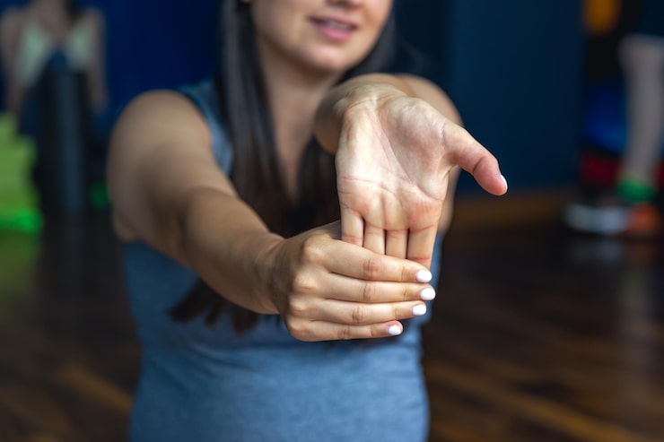 Mujer realizando ejercicios de calentamiento sobre una colchoneta como parte de un programa de rehabilitación
