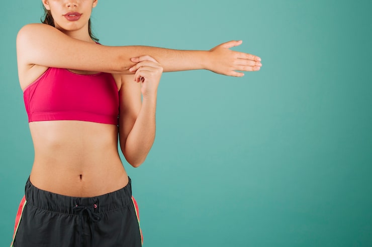 Mujer estirando los brazos antes de entrenar como parte de un programa de ejercicios para el codo